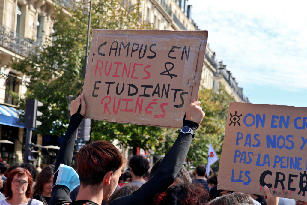 Pancarte « Campus en ruines & étudiants ruinés » lors de la manifestation du mouvement lycéen du 6 octobre 2026 à Paris