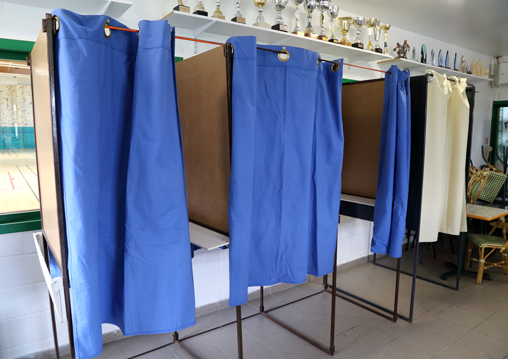 isoloirs dans un bureau de vote, symbole de la démocratie participative en ligne